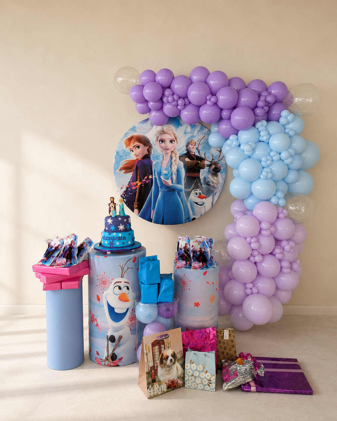Decoración infantil en lila, azul y blanco con globos y mesa de regalos