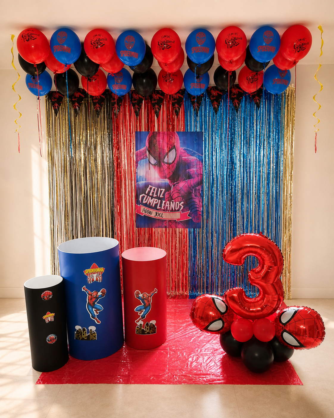 Decoración infantil en rojo, azul y negro con cortina de flecos y número tres